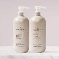 Two bottles of Neal & Wolf HYDRATE Moisture Shampoo and Conditioner, with pump dispensers, on a light background.
